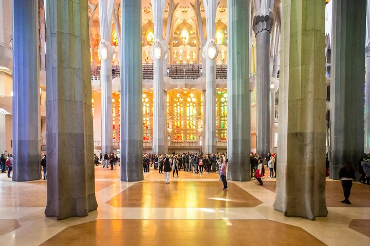 Besucher zwischen den hohen, baumartigen Säulen des Mittelschiffs der Sagrada Familia